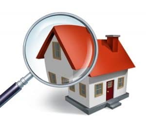11840300 - house hunting and searching for real estate homes for sale that need to be inspected by a home inspector concept as a magnifying glass inspecting a model single home building structure.