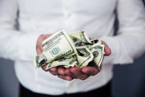 Closeup image of a business man hands holding money bills of US dollar