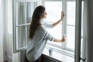 Woman,Is,Opening,Window,To,Look,At,Beautiful,Snowy,Landscape