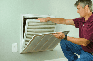 Maintenance man changing fresh air filter shutterstock_449846074