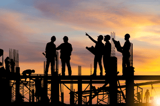 Construction workers at sunset shutterstock_1933884635
