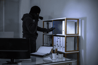 Burglar stealing papers shutterstock_1068480200