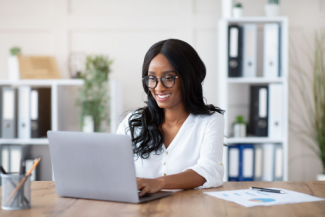 Lady on computer Shutterstock_1923680471