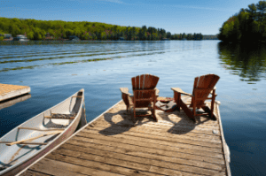 Adirondack chairs on lake Shutterstock_1433565950