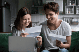 Happy couple reading letter Shutterstock_1095874397