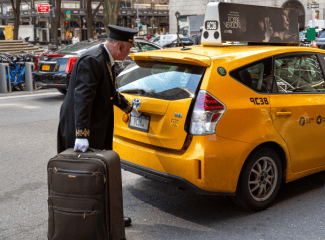 NYC Doorman and taxi Shutterstock_1406129354