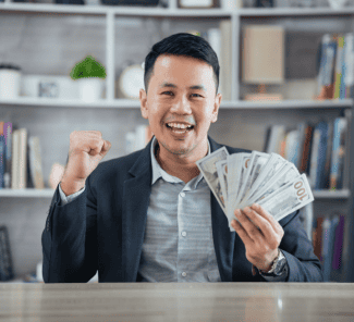Happy man with fistful of money Shutterstock_2230683439