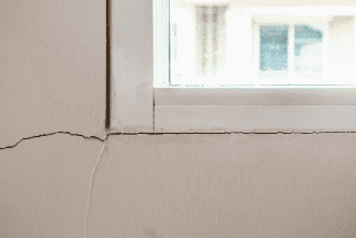 Wall crack near window Shutterstock_1203132853