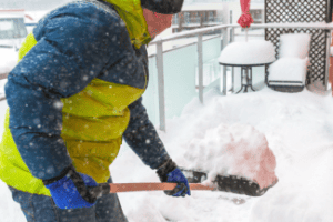 Shoveling snow on a balcony Shutterstock_558786838