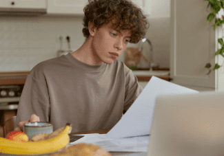 Young man studying paper Shutterstock_2264625273