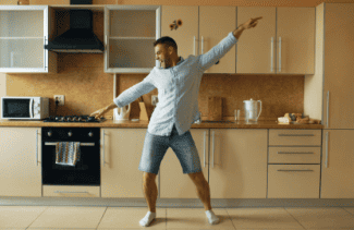 Man dancing alone in kitchen Shutterstock_771308572